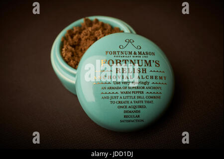 Fortnum and Mason, Fortnum's Relish Anchovial Alchemy in a small porcelain pot with gold lettering on a slate background Stock Photo