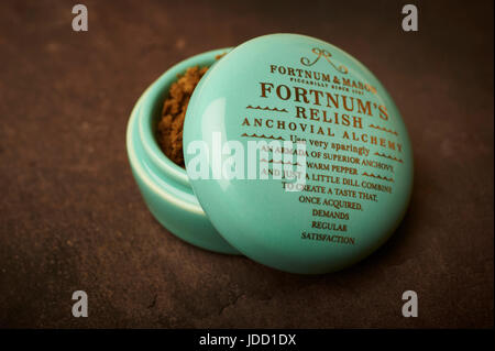Fortnum and Mason, Fortnum's Relish Anchovial Alchemy in a small porcelain pot with gold lettering on a slate background Stock Photo