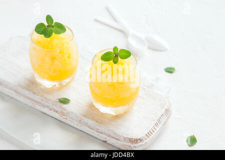 Lemon Frozen Granita Slush Drink on white table. Homemade Italian Granita Dessert, refreshing summer Slush Drink. Stock Photo