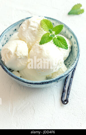 Vanilla Ice Cream with Mint in blue ceramic bowl. Homemade Ice Cream, copy space. Stock Photo