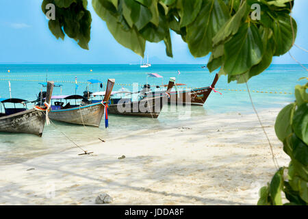 Longtail boats on Thailand beach with tree Stock Photo