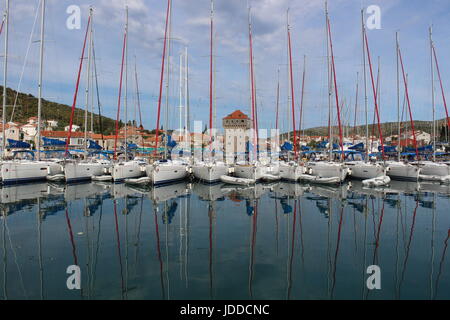 Early morning image of twelve Sunsail yachts reflecting in harbour at Marina, Croatia with tower in the middke Stock Photo