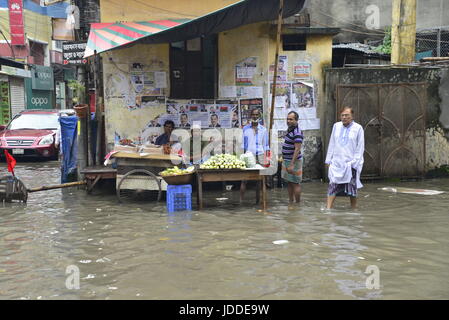 Dhaka, Bangladesh. 19th Jun, 2017. Street vendor waits for customer in the flooded streets of Dhaka after heavy rainfalls caused almost-standstill, on June19, 2015. After heavy monsoon rains caused flooded most of area in the capital of Dhaka in Bangladesh. Roads were partially submerged making travel hazardous. A number of cycle rickshaws overturned in the water. Credit: Mamunur Rashid/Alamy Live News Stock Photo