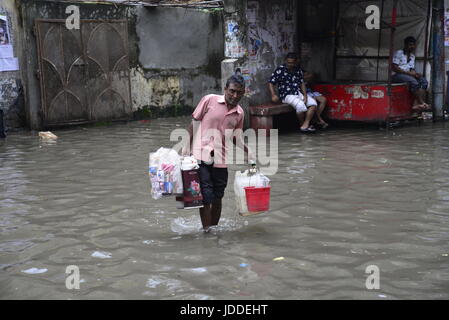 Dhaka, Bangladesh. 19th Jun, 2017. Citizens walking through the flooded streets of Dhaka after heavy rainfalls caused almost-standstill, on June19, 2015. After heavy monsoon rains caused flooded most of area in the capital of Dhaka in Bangladesh. Roads were partially submerged making travel hazardous. A number of cycle rickshaws overturned in the water. Credit: Mamunur Rashid/Alamy Live News Stock Photo