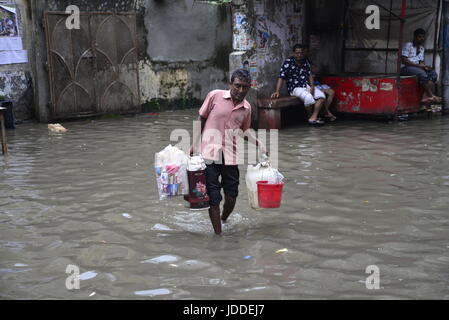 Dhaka, Bangladesh. 19th Jun, 2017. Citizens walking through the flooded streets of Dhaka after heavy rainfalls caused almost-standstill, on June19, 2015. After heavy monsoon rains caused flooded most of area in the capital of Dhaka in Bangladesh. Roads were partially submerged making travel hazardous. A number of cycle rickshaws overturned in the water. Credit: Mamunur Rashid/Alamy Live News Stock Photo