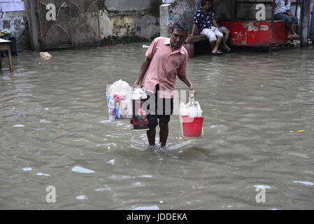 Dhaka, Bangladesh. 19th Jun, 2017. Citizens walking through the flooded streets of Dhaka after heavy rainfalls caused almost-standstill, on June19, 2015. After heavy monsoon rains caused flooded most of area in the capital of Dhaka in Bangladesh. Roads were partially submerged making travel hazardous. A number of cycle rickshaws overturned in the water. Credit: Mamunur Rashid/Alamy Live News Stock Photo