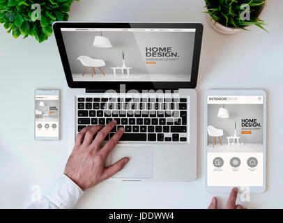 office tabletop with tablet, smartphone and laptop showing cool responsive interior design website Stock Photo