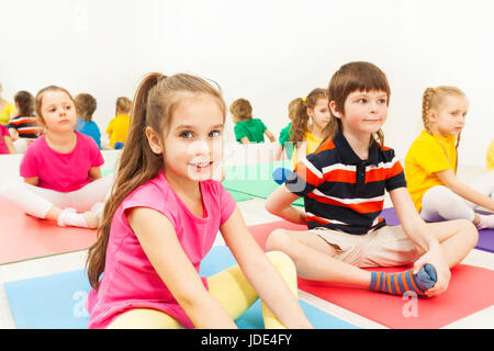 Close-up portrait of smiling six years old girl sitting in butterfly pose during kid's yoga class Stock Photo