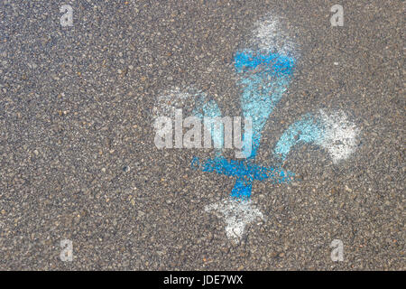 White and blue fleur-de-lis painted on asphalt. Fleur-de-lis is the symbol of Quebec province. Stock Photo