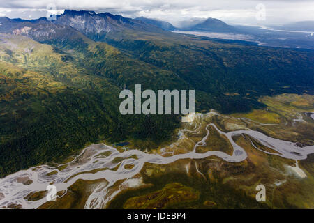 Winding braided river and mountains dominate Alaska landscape rich with green and yellow forest colors Stock Photo