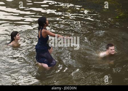 Students swim in the river Cam after attending a May Ball at Cambridge University which is the traditional celebration to mark the end of the academic year. Stock Photo
