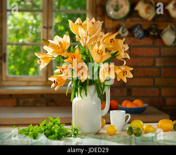 Still life with lily flowers and fruits Stock Photo - Alamy