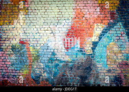 Multi coloured graffiti painted brick wall background Stock Photo