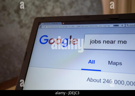 A notebook display shows Google search engine for “jobs near me' Stock Photo