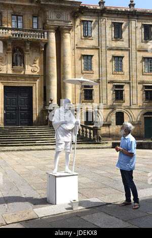 Man talking to mime artist dressed as Mahatma Gandhi in Santiago de Compostela in Northern Spain Stock Photo