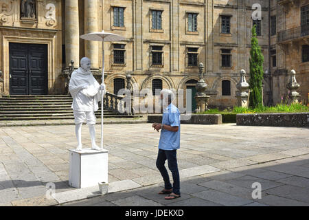 Man talking to mime artist dressed as Mahatma Gandhi in Santiago de Compostela in Northern Spain Stock Photo