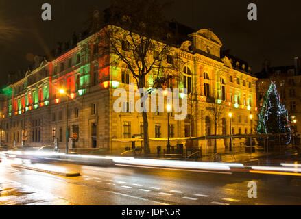 View of Mayor of the 4th Arrondissement building at night in Paris. Light trails of cars in motion create dramatic and dynamic ambiance. Stock Photo