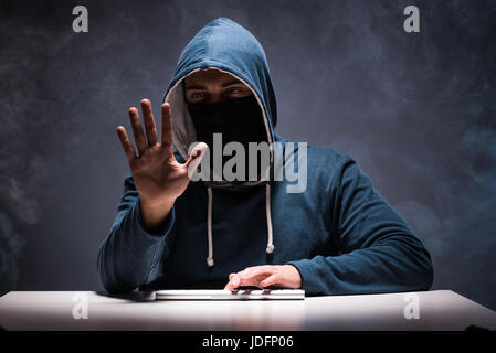 Computer hacker working in dark room Stock Photo