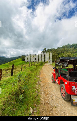 SALENTO, COLOMBIA - JUNE 7: A red jeep parked near pastures in the mountains outside of Salento, Colombia on June 7, 2016. Stock Photo