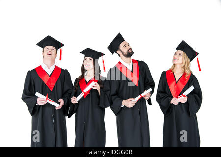 Group of young men and women in graduation gowns and mortarboards holding diplomas Stock Photo