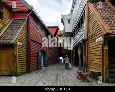 Tourists in Jacobsfjorden and Bellgarden with Hanseatic commercial wooden buildings on each side of passageway Bryggen Bergen Norway UNESCO World Heri Stock Photo