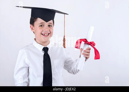 Smiling boy with diploma in graduation Stock Photo