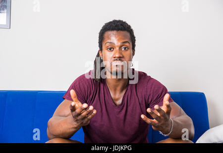 Handsome unsure, doubtful black man thinking, looking up with dubious expression on his face Stock Photo