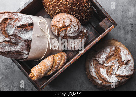 A basket full of delicious freshly baked bread on wooden background Stock Photo