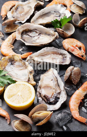 Fresh seafood on stone table. Oysters, prawns and scallops. Top view Stock Photo