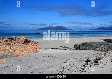 A Little Red Fishing Boat Sailing on the Sound of Harris Below Ceapabhal Hill on the Island of Berneray on North Uist, Outer Hebrides,Scotland. Stock Photo