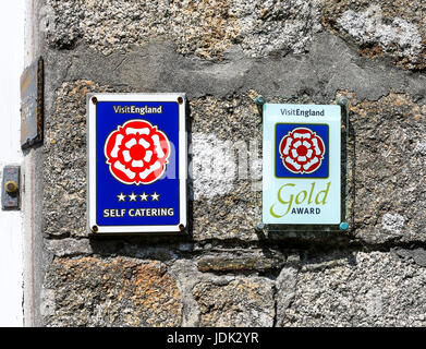 Visit England self catering signs, 4 star and gold award on a cottage wall at Hugh Town St. Mary's, Isles of Scilly, Cornwall, England, UK Stock Photo