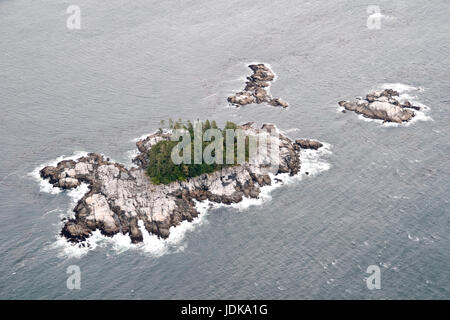 Aerial view of a small rocky uninhabited islet at low tide in the North Pacific in the Great Bear Rainforest, central coast, British Columbia, Canada. Stock Photo