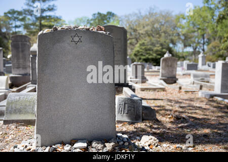 Headstone in a Jewish cemetery with Star of David and memory stones.  Selective focus on the foreground.  Copy space. Stock Photo