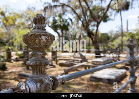Historic Bonaventure Cemetery in Savannah, GA.  Old rusty wrought iron post and fence.  Selective focus on foreground to accommodate copy if needed. Stock Photo