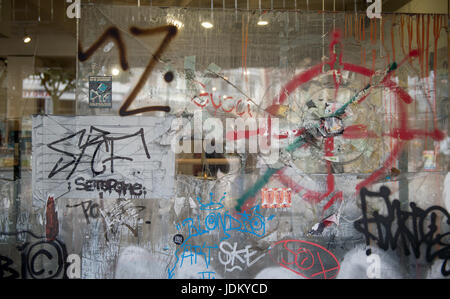 Hamburg, Germany. 21st June, 2017. A broken shop window is decorated with stickers and graffiti in the Schanze district of Hamburg, Germany, 21 June 2017. The G20 Summit will take place in Hamburg in July. Photo: Axel Heimken/dpa/Alamy Live News Stock Photo