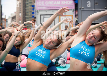 New York, USA. 21st June, 2017. Over 12,000 yoga practitioners pack Times Square in New York to practice yoga on the first day of summer, Wednesday, June 21, 2017. The 15th annual Solstice in Times Square, 'Mind Over Madness', stretches the yogis' ability to block out the noise and the visual clutter that surround them in the Crossroads of the World. ( © Richard B. Levine) Credit: Richard Levine/Alamy Live News Stock Photo
