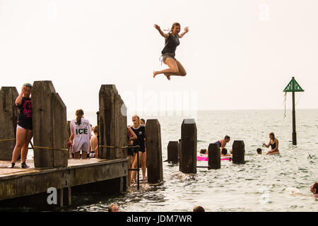 Aberystwyth Wales UK, Wednesday 21 June 2017 UK Weather: Groups of teenage boys and girls cooling off by jumping into the sea off the jetty in Aberystwyth at the end Solstice Day, and what is expected to be the last day of the current period of hot and sultry weather as the mini heat-wave continues today over the British Isles. The Met Office has warned of heavy rain and thunderstorms with the chance of localized flooding affecting much of the UK in the next 24 hours as the weather system starts to break down after many days of record hight temperatures Credit: keith morris/Alamy Live News Stock Photo