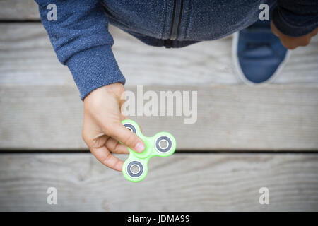 Child spinning a fidget spinner toy. Top view Stock Photo