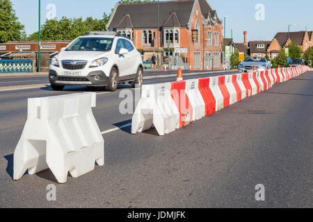 Temporary road lane closure with red and white interlocking traffic barrier sections forming one long barrier, Nottingham, England, UK Stock Photo