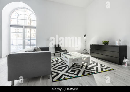 White living room with gray sofa, pallet table and black cabinet Stock Photo