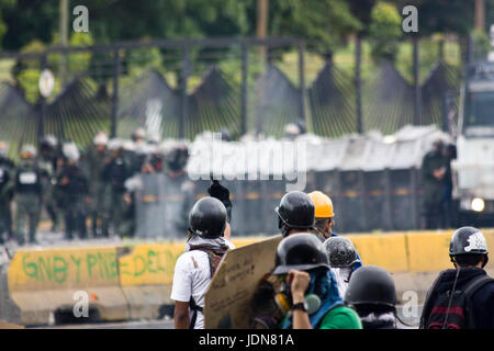 Demonstrators confront the Bolivarian National Guard during a protest on highway in Caracas. Stock Photo