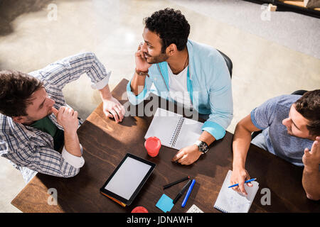Overhead view of young concentrated men working on project at small office meeting Stock Photo