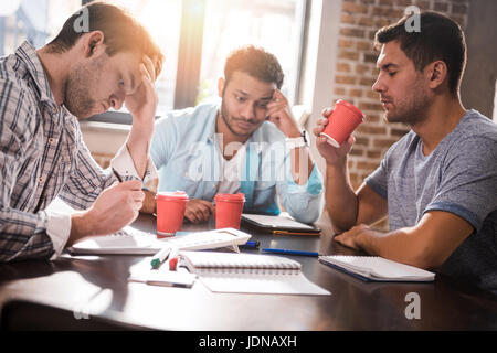 Group of concentrated young professionals working on business project together Stock Photo