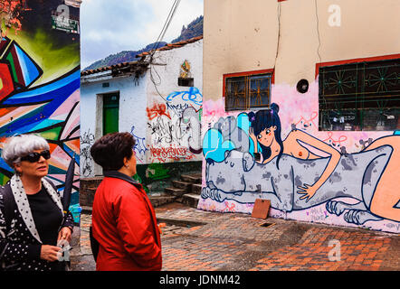 Bogota, Colombia - A couple of local Colombian tourists admire Street Art on the square called Chorro de Quevedo in the La Candelaria district. Stock Photo