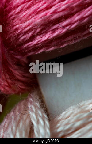 Pale pink and purple sewing threads pattern macro Stock Photo