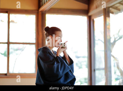 Caucasian woman wearing yukata at traditional ryokan, Tokyo, Japan Stock Photo