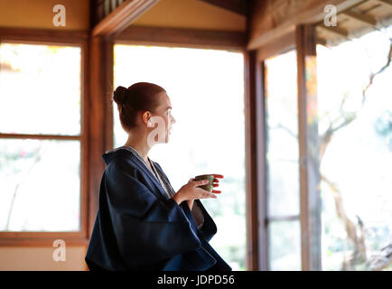 Caucasian woman wearing yukata at traditional ryokan, Tokyo, Japan Stock Photo