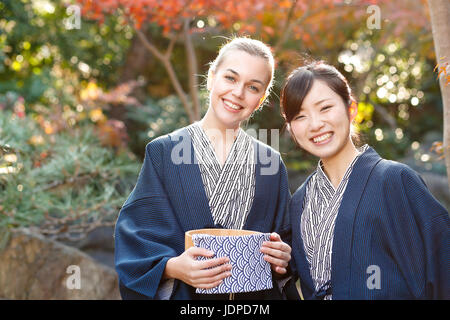 Caucasian woman wearing yukata with Japanese friend at traditional ryokan, Tokyo, Japan Stock Photo