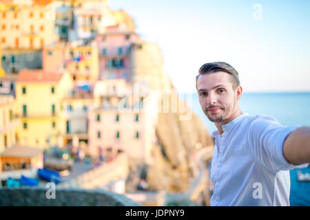 Tourist looking at scenic view of Manarola, Cinque Terre, Liguria, Italy Stock Photo
