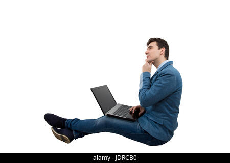 Young serious businessman with a thoughtful look sitting down on floor using laptop.Idea and Future concept. Stock Photo